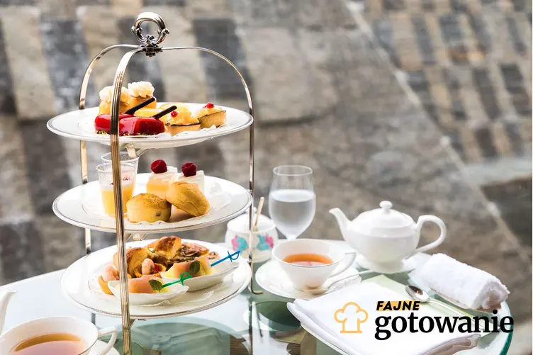 Na zdjęciu przedsatwione są filiżanki z herbatą oraz patera z potrawami.