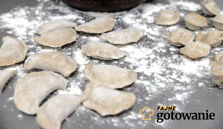 Pierogi bezglutenowe surowe ułożone na drewnianej stolnicy