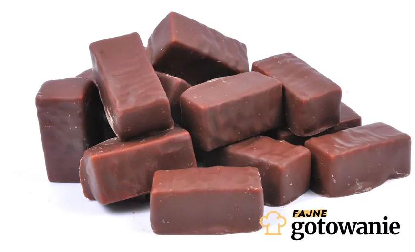 Ptasie Mleczko® to kultowy produkt, który kochają wszyscy Mleczne pianki w czekoladzie ułożone na białym tle