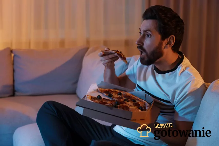 Mężczyzna je pizzę podczas oglądania TV
