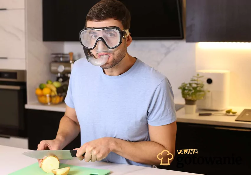 Krojenie cebuli bardzo często kończy się łzami, ale nie zawsze musi tak być Mężczyzna w goglach do pływania krojący cebulę