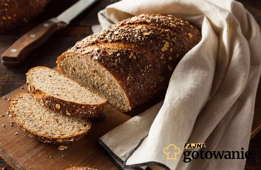 Pieczywo jest zdrowym elementem diety, dlatego warto wiedzieć jak je prawidłowo przechowywać Chleb z ziarnami pokrojony w kromki, okryty lnianą ściereczką
