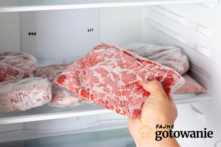 Mężczyzna wyjmuje mięso z zamrażarki