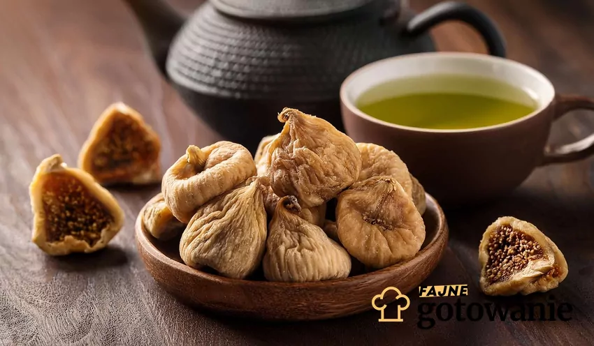 Suszone figi w drewnianej miseczce, w tle czajniczek z herbatą