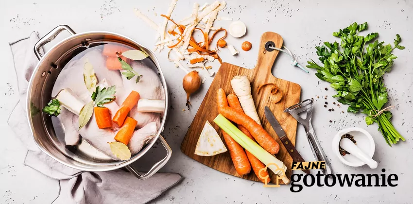 Widok z góry na garnek z rosołem, obok składniki do rosołu