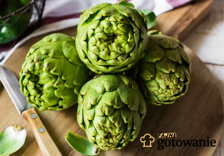 Karczoch to warzywo wyjątkowo korzystne dla układu pokarmowego i metabolicznego Świeże karczochy ułożone na drewnianej desce