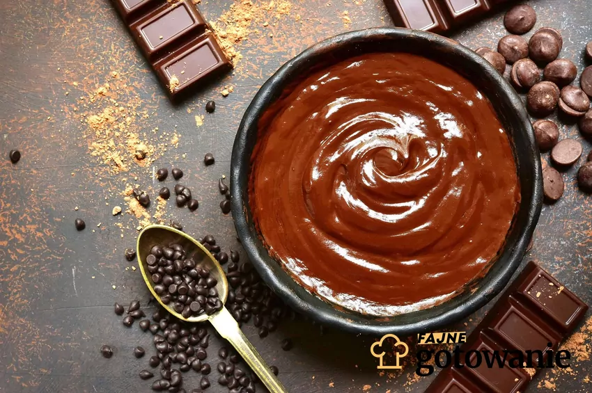 Tabliczki czekolady stały się popularne dopiero w XIX wieku, kiedy powstały pierwsze fabryki słodyczy Roztopiona czekolada w miseczce, wokół kawałki czekolady