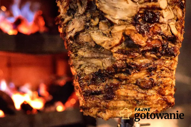 Mięso gyros na specjalnym ruszcie, w tle piec z ogniem, a także co innego niż danie można przygotować w stylu gyros