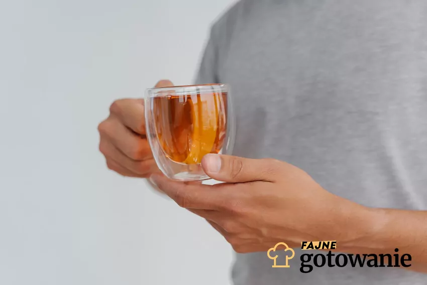 Zioła te w zbyt dużych dawkach mogą pogarszać pracę wątroby lub jelit Meżczyzna trzyma szklankę z naparem