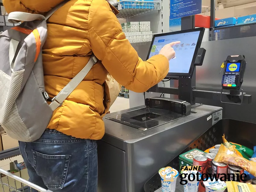 Klient stoi przy kasie samoobsługowej w Lidlu