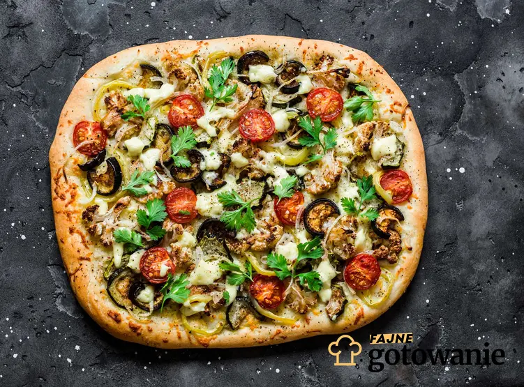 Pizza z twarogiem i warzywami podana na ciemnym tle.