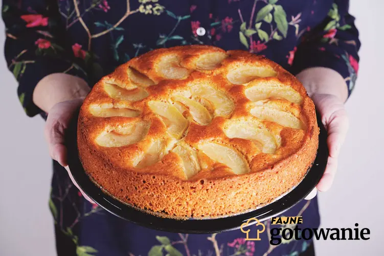 Ciasto z dynią i jabłkami podane na ciemnym talerzu.