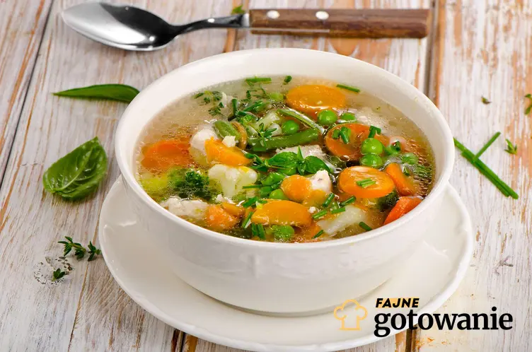 Lekka zupa z warzywami podana w eleganckiej misce.