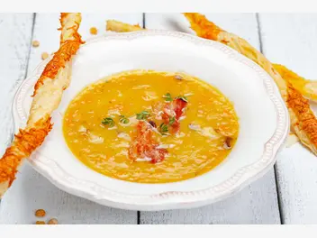 Ilustracja przepisu na: zupa krem z soczewicy zielonej z chipsami z boczku i prażonymi pistacjami