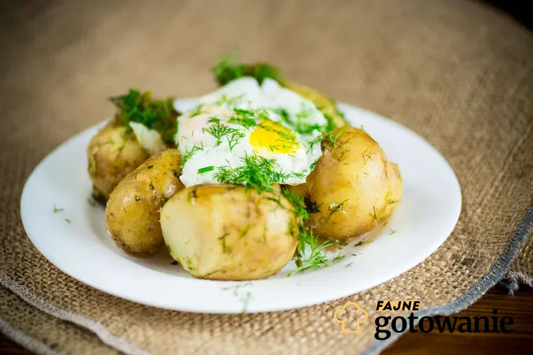 Jajka sadzone z ziemniakami podane na białym talerzu.