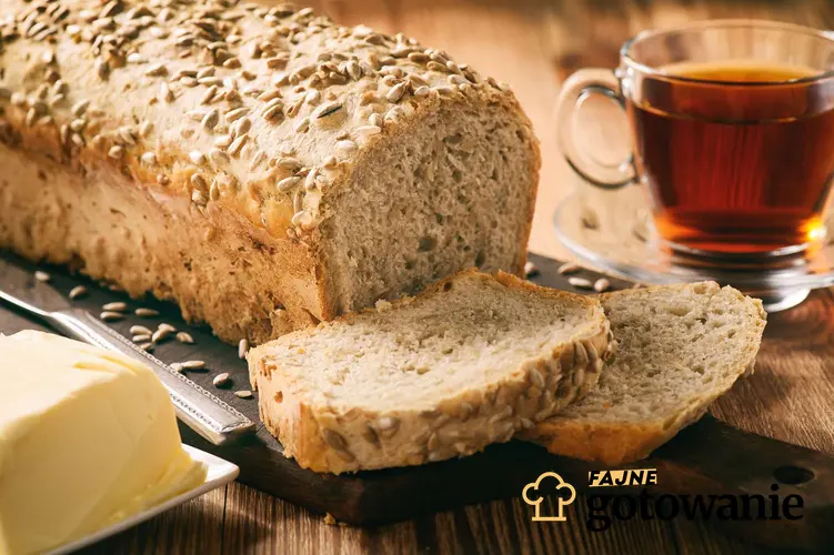 Chleb żytni ze słonecznikiem podany na desce do krojenia.