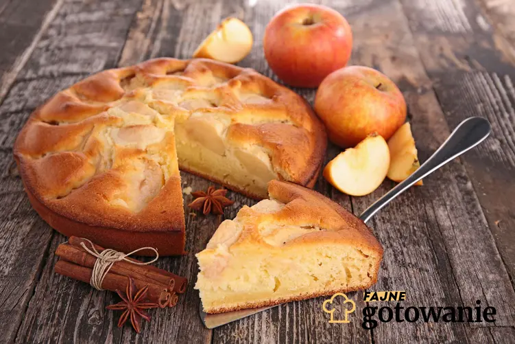 Ciasto na oleju z jabłkami i cynamonem podane na drewnianym blacie.