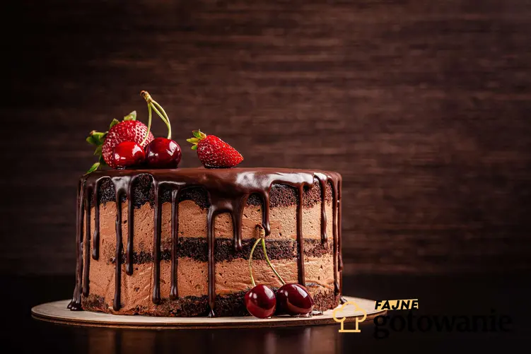 Tort czekoladowy z wiśniami i serkiem mascarpone podany na podkładce.