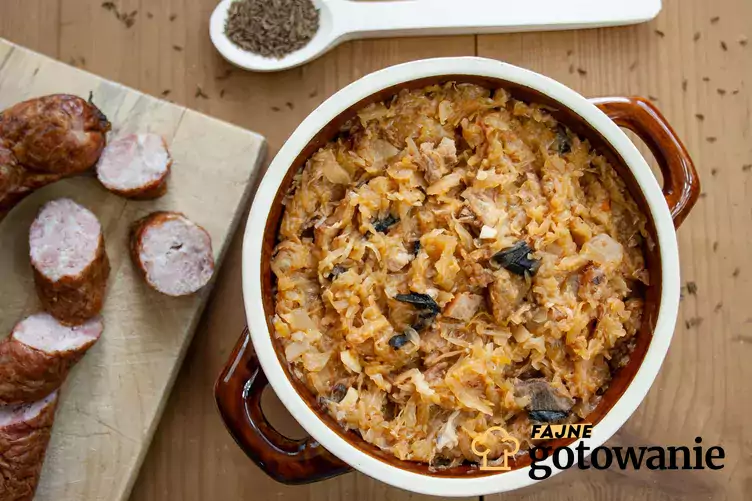 Bigos z pieczarkami podany w naczyniu z kamionki.