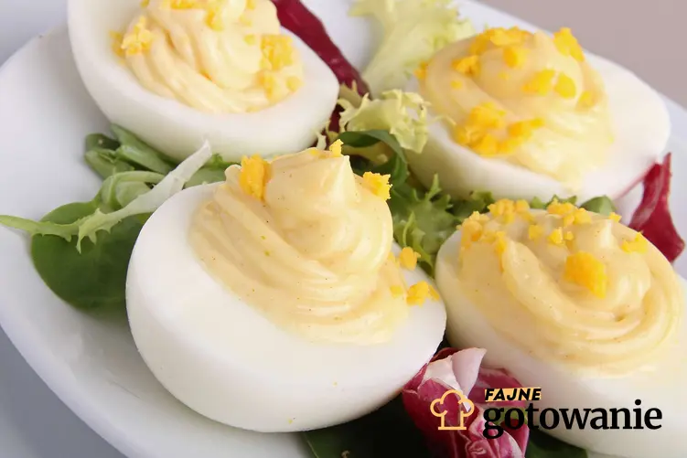 Jajka w majonezie leżą na białym talerzu.