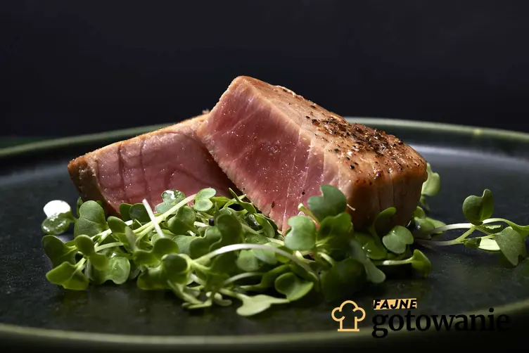 Polędwica z tuńczyka podana na eleganckim talerzu z sałatą.