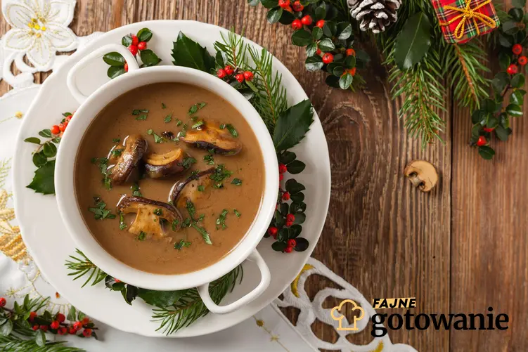 Zupa grzybowa na wigilię podana w bulionówce, otoczona świątecznymi dekoracjami.