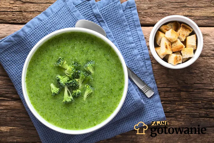 Zupa krem brokułowa podana w eleganckiej miseczce i udekorowana różyczkami brokułu.