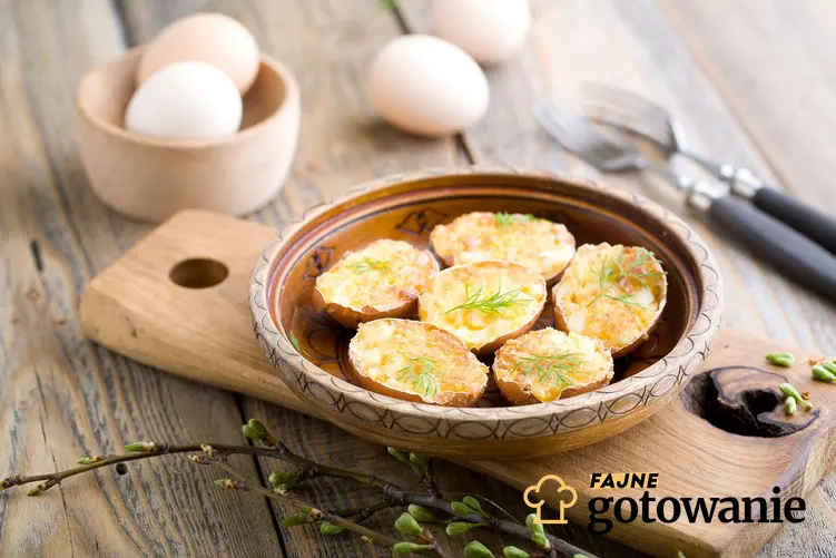 Jajka smażone w skorupkach w miseczce ustawionej na drewnianej desce