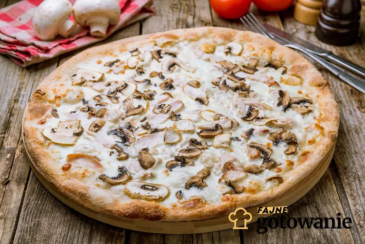 Pizza z pieczarkami podana na drewnianym blacie.