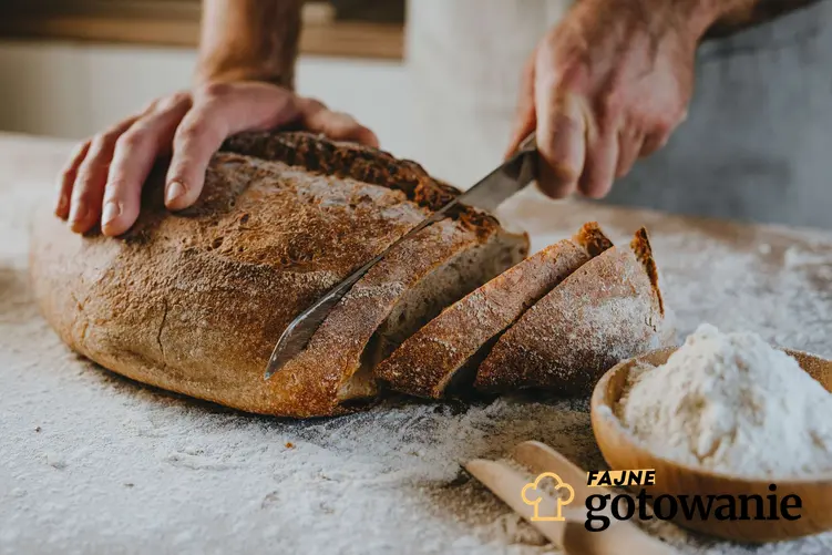 Keto chleb krojony nożem przez piekarza znajduje się na blacie posypanym mąką.