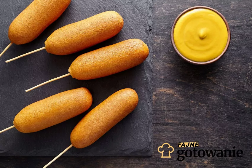 Corn dog z miseczką sosu.