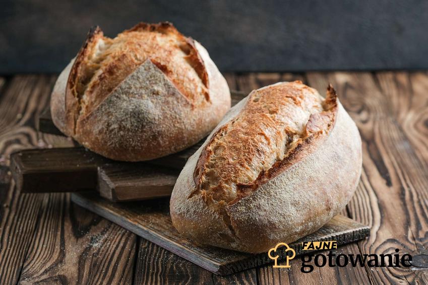 Chleb z mąki orkiszowej ulożony na drewnianych deskach do krojenia.