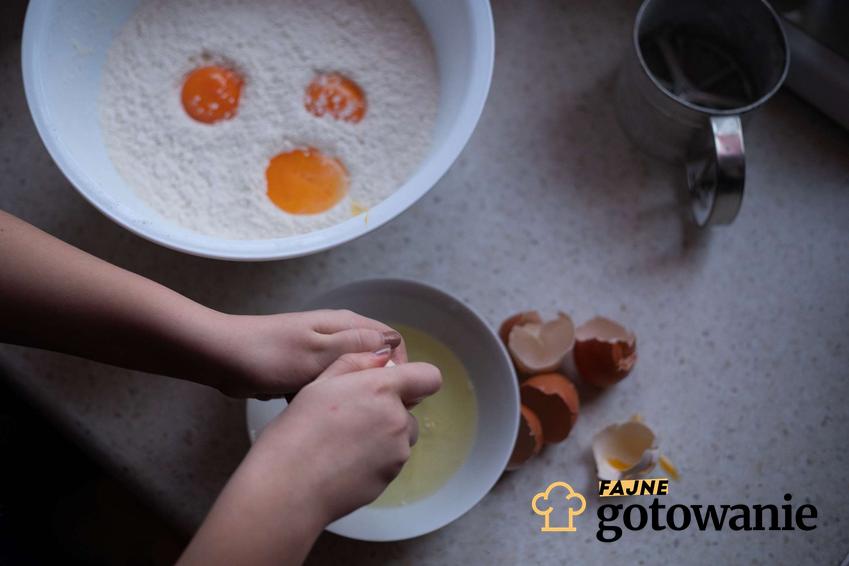 Przygotowywanie ciasta, wbijanie jajek do miski.