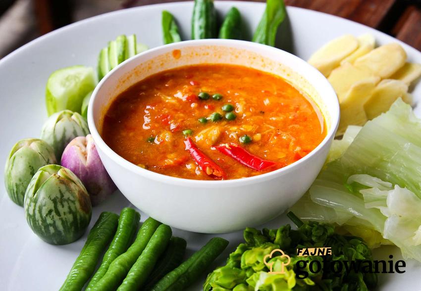 Zupa solferino podana w eleganckiej miseczce w towarzystwie warzyw.