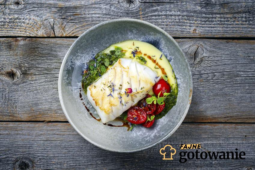 Ryba po polsku podana na eleganckim półmisku z warzywami.