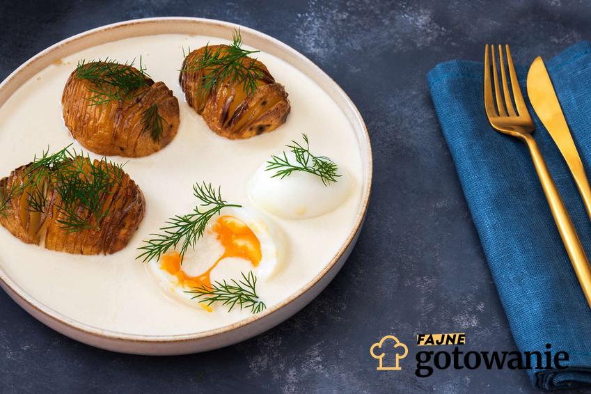 Jajka w sosie chrzanowym podane na eleganckim talerzu z ziemniakami.