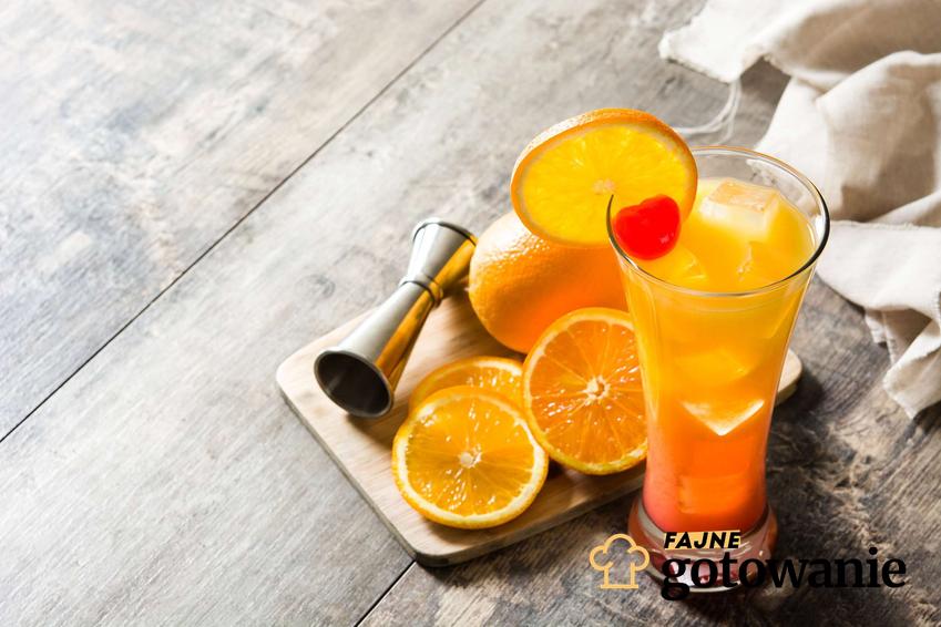 Tequila sunrise podana w małym kieliszku i udekorowana pomarańczami.