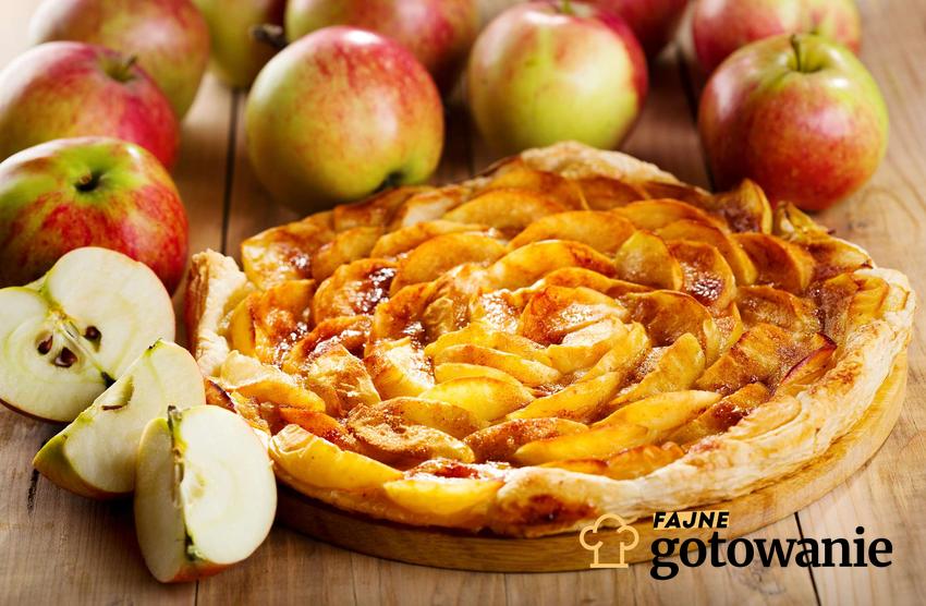 Wegańskie ciasto z jabłkami podane na desce z owocami.