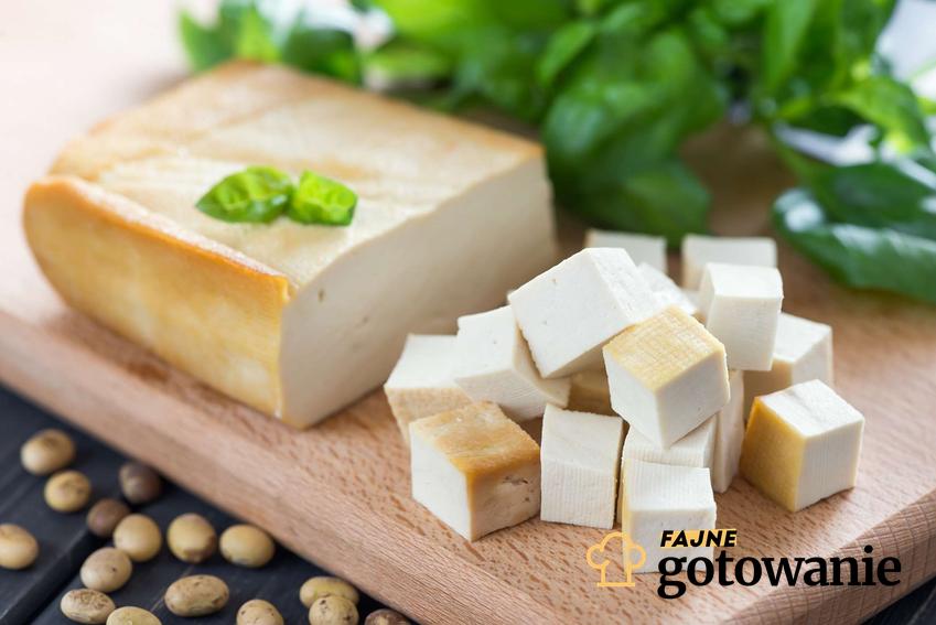 Tofu wędzone podane na drewnianej desce i udekorowane pietruszką.