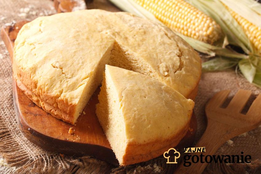 Chleb z mąki kukurydzianej podany na drewnianej desce do krojenia. W oddali leżą kolby kukurydzy.