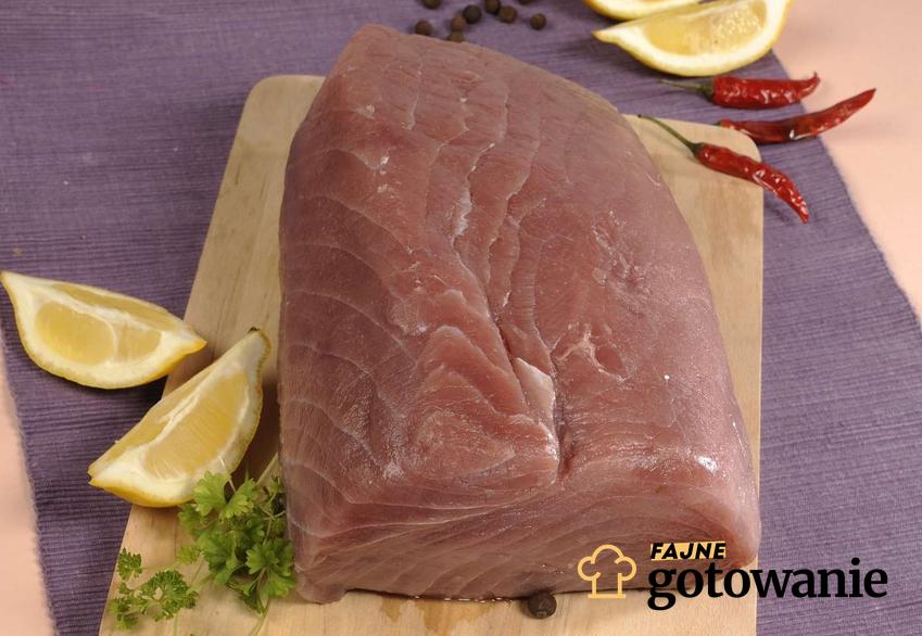 Stek z tuńczyka udekorowany ćwiartkami cytryny i papryczki chilli.
