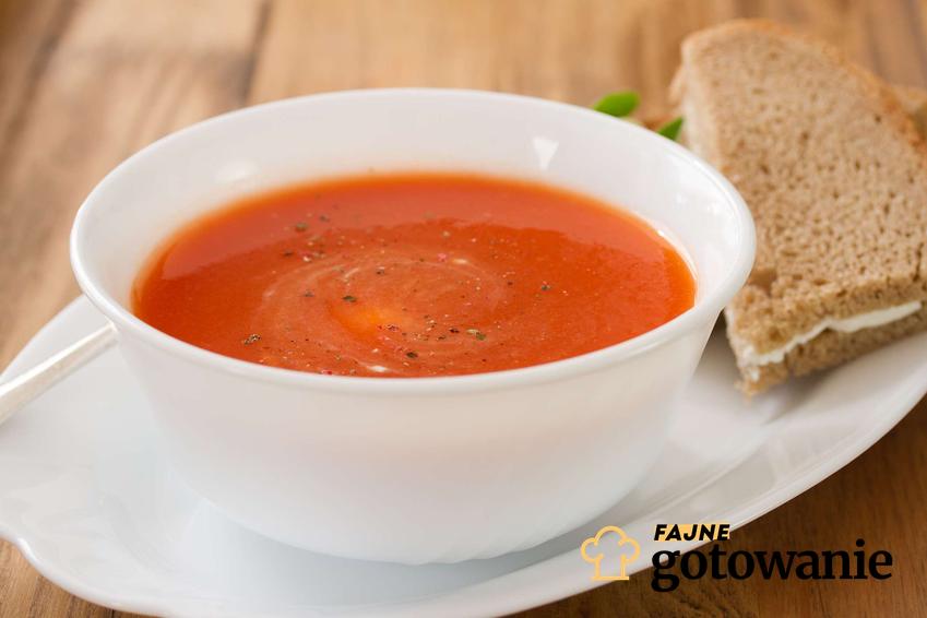 Zupa pomidorowa z przecieru podana w białej miseczce.