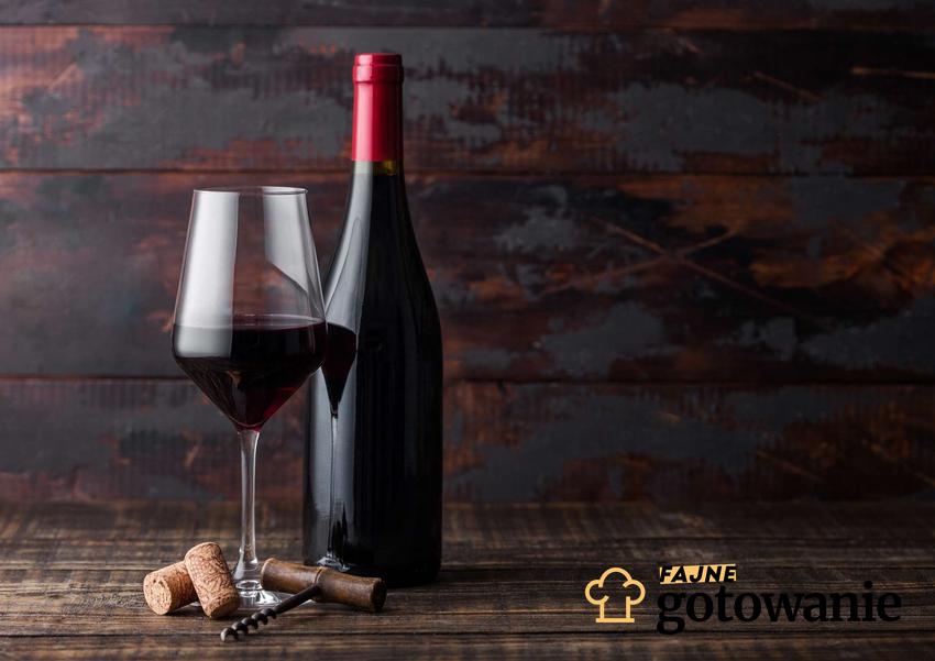 Wino z aronii podane w kieliszku oraz szklanej butelce.